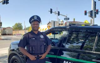 a law enforcement officer in uniform standing near a police vehicle