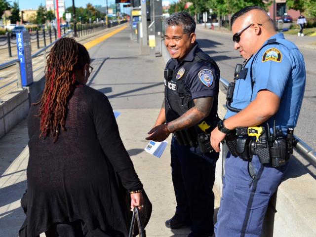 woman and two policemen near light rail line