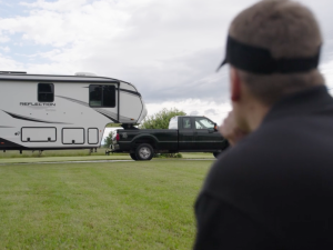 Man looking at his RV which is being towed by his truck