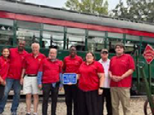 people in red shirts in front of a trolley