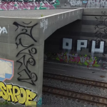 an image of a graffiti covered railroad facility with train tracks