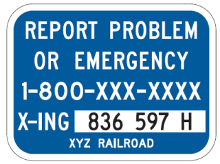 A blue sign showing railroad emergency number and DOT crossing number