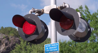 close up of railroad crossing lights and ens sign