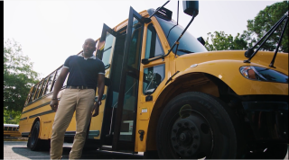 a man standing next to a school bus