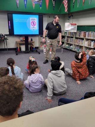 Volunteer presents a rail safety presentation to elementary students.