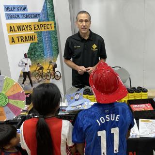 Volunteer sharing a rail safety message with event attendees.
